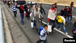 Venezuelan migrants walk along the Ecuadorean highway to Peru before new rules requiring they hold a valid passport kick in, at Tulcan, Ecuador, Aug. 21, 2018. 