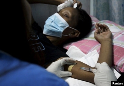 Seorang petugas kesehatan memasukkan kontrasepsi suntik ke lengan seorang wanita di klinik kesehatan reproduksi yang dijalankan oleh sebuah Lembaga Swadaya Masyarakat di kota Tondo, metro Manila, Filipina, 12 Januari 2016. (Foto: Reuters)