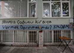 FILE - Graffiti on a wall reads, "Does getting shelter mean paying most of your salary for rent?" in Istanbul, Turkey Oct. 15, 2021.