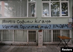 FILE - Graffiti on a wall reads, "Does getting shelter mean paying most of your salary for rent?" in Istanbul, Turkey Oct. 15, 2021.
