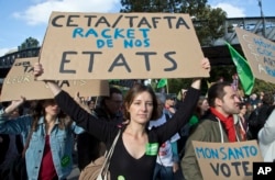 CETA Trade Deal: A protester holds a placard which reads, "CETA/TAFTA steel our States" during a rally to protest against the trade deals with Canada and the U.S. in Paris, Saturday, Oct. 15, 2016.