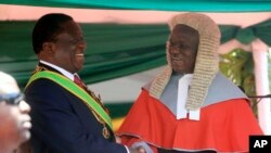 FILE: Zimbabwean President Emmerson Mnangagwa,left, is congratulated by Chief Justice Luke Malaba after taking his oath during his inauguration ceremony at the National Sports Stadium in Harare, Sunday, Aug. 26, 2018. 