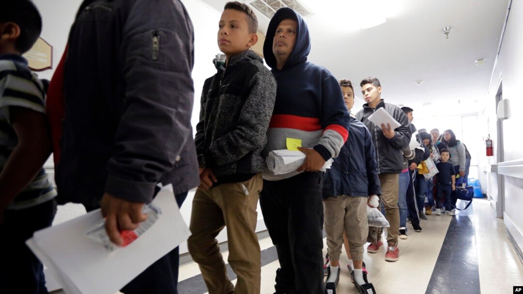 A line of migrants recently released by U.S. immigration authorities waits to check in at the Catholic Charities shelter in McAllen, Texas, Jan. 11, 2019.