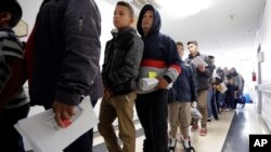 Des immigrants récemment libérés par les autorités de l’immigration américaines attendent de s’enregistrer, Texas, le 11 janvier 2019.