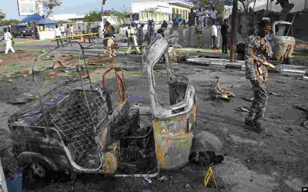 Un soldat somalien passe devant une moto après l&#39;explosion d&#39;une voiture piégée près du Parlement, à Mogadiscio, en Somalie, le 25 mars 2018.