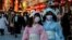 Visitors wearing protective face masks walk under decorations for the New Year at Nakamise street leading to Senso-ji temple at Asakusa district, a popular sightseeing spot, amid the coronavirus disease (COVID-19) pandemic, in Tokyo, Dec. 24, 2021. 