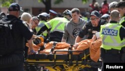 A woman is taken away by ambulance after reports of shots fired in the area where crowds gathered to celebrate the Toronto Raptors victory parade in Toronto, Ontario, Canada, June 17, 2019. 