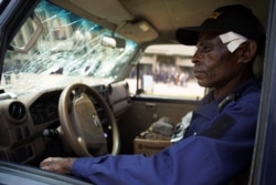 FILE - Wounded Officer Nsonso Lenga Lambert sits in a police vehicle that was damaged when two groups of Muslims clashed outside Martyrs Stadium in Kinshasa, Democratic Republic of the Congo, May 13, 2021.