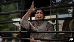 An activist who had come to support protesting wrestlers shouts slogans as she is detained by the police while trying to join a march towards the newly inaugurated parliament, in New Delhi, India, May, 28, 2023.