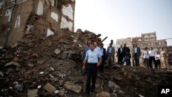 Peter Maurer, the president of the International Committee of the Red Cross, center, walks near houses destroyed by a Saudi-led airstrike during his visit to the old city of Sana'a, Yemen, Aug. 9, 2015.