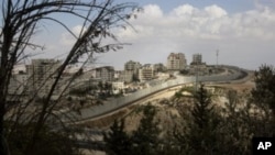 A general view shows the Palestinian Shuafat refugee camp behind Israel's controversial separation barrier in east Jerusalem, 09 Oct 2010