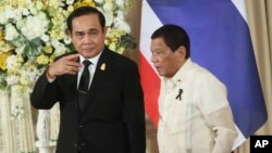 Philippine President Rodrigo Duterte, right, and Thailand's Prime Minister Prayuth Chan-ocha walk together as they leave a joint news conference at the government house in Bangkok, Thailand, March 21, 2017. Duterte is in Thailand for a two-day visit, roun