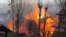 Flames and smoke billow from residential houses after they caught fire during a gunbattle between Indian army soldiers and suspected militants at Kachdoora village in south Kashmir's Shopian district, Apr. 1, 2018.
