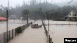 Bomberos captados en labores de rescate de residentes en una zona inundada afectada por fuertes lluvias, en Concepción, Chile, 12 de junio de 2024.