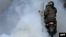 Militares de la Guardia Nacional Bolivariana de Venezuela lanzan bombas lacrimógenas durante una manifestación contra los resultados electorales, en Caracas, el 30 de julio de 2024.