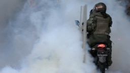 Militares de la Guardia Nacional Bolivariana de Venezuela lanzan bombas lacrimógenas durante una manifestación contra los resultados electorales, en Caracas, el 30 de julio de 2024.