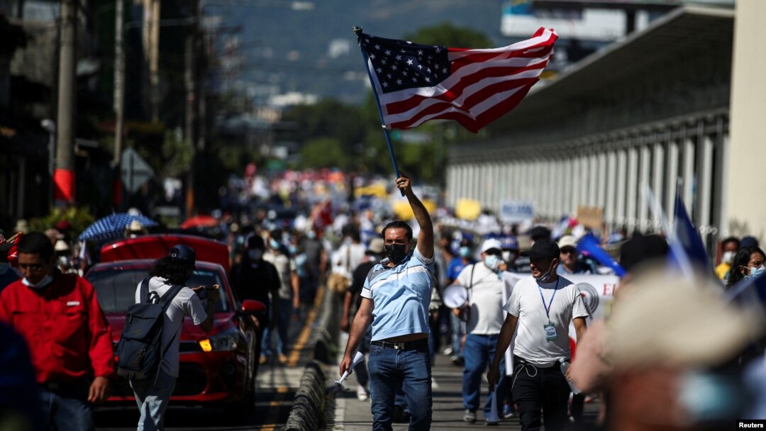 Un hombre ondea una bandera estadounidense durante una protesta contra acciones del gobierno del presidente de El Salvador, Nayib Bukele, como el uso de bitcoin y reformas legales para extender su mandato, en San Salvador, El Salvador, el 12 de diciembre de 2021.
