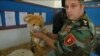 A Kurdish fighter holds a stuffed teddy bear, used to conceal a weapon. It's just one item gathered from battles against Islamic State militants and to be displayed as part of a museum in Duhok, Iraq. (VOA/Kawa Omar)