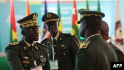 Des membres des Forces armées du Sénégal discutent en marge de la session extraordinaire des chefs d'État et de gouvernement de la Communauté économique des États de l'Afrique de l'Ouest (CEDEAO) à Abuja, le 10 août 2023.