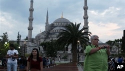 Des touristes prennent des photographies en face de la Mosquée bleue à Istanbul, Turquie, le 4 juin 2013.