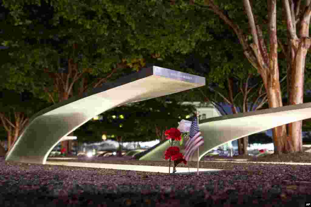 Flowers and a flag adorn one of the memorial benches outside the Pentagon before the start of a dawn 9/11 remembrance ceremony in Washington.