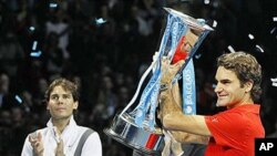 Switzerland's Roger Federer celebrates as he holds the trophy after beating Spain's Rafael Nadal, left, to win the singles final tennis match at the ATP World Tour Finals at the O2 Arena in London, Nov. 28, 2010