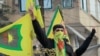 FILE - Syrian Kurds flash the V for victory sign as they celebrate the fall of capital Damascus to rebel fighters, in the city of Qamishli on Dec. 8, 2024.