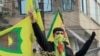 FILE - Syrian Kurds flash the V for victory sign as they celebrate the fall of capital Damascus to anti-government fighters, in the city of Qamishli on December 8, 2024.