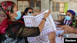 Empleadas electorales indígenas preparan materiales de votación y boletas en el estado de Oaxaca para las elecciones parciales en México del 6 de junio de 2021.