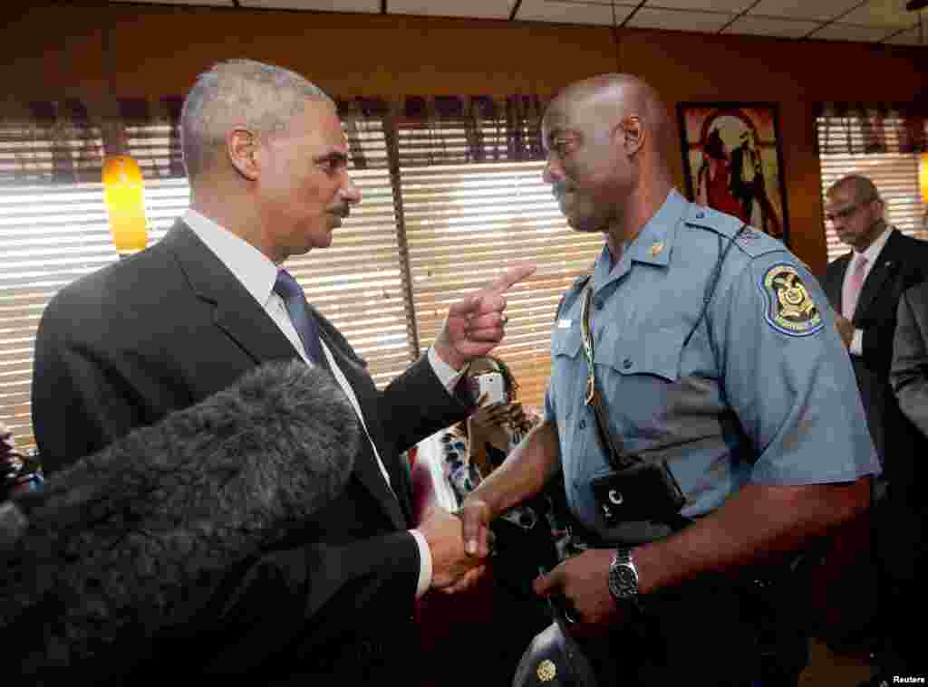 Jaksa Agung AS Eric Holder berbicara dengan Kapten Ron Johnson dari Patroli Jalan Layang Missouri di Restauran Drake&#39;s Place di Ferguson, Missouri (20/8). (Reuters/Pablo Martinez Monsivais)