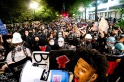 FILE - Black Lives Matter protesters march through Portland, Ore. after rallying at the Mark O. Hatfield United States Courthouse on Sunday, Aug. 2, 2020.