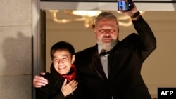 FILE - Nobel Peace Prize laureates Maria Ressa of the Philippines, left, and Dmitry Muratov of Russia wave from the balcony of the Grand Hotel in Oslo, Dec. 10, 2021.