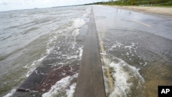 Waters from the Guld of Mexico poor onto a local road, Monday, Sept. 14, 2020, in Waveland, Miss. Hurricane Sally, one of a record-tying five storms churning simultaneously in the Atlantic, closed in on the Gulf Coast on Monday with rapidly…