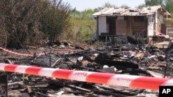 FILE - A Gypsy camp on the outskirts of Rome lies in ruins after a fire, possibly caused by a candle, Aug. 27, 2010.
