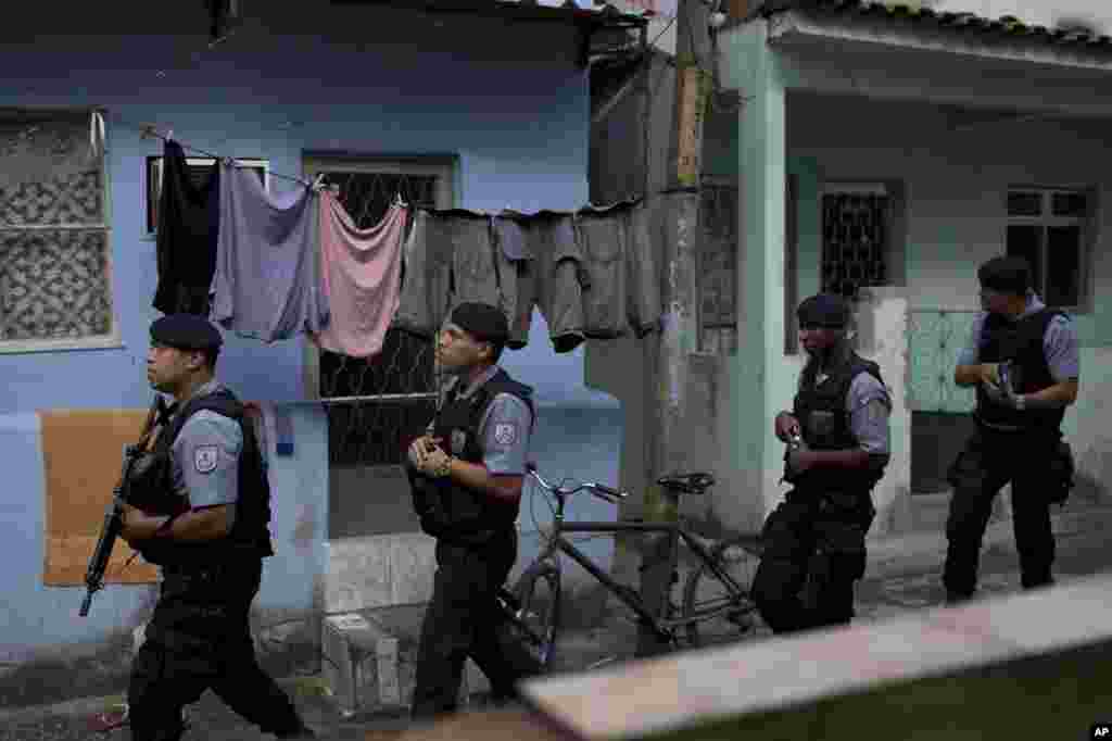 Polisi Brazil menjaga kompleks Varginha di daerah kumuh Manhuinhos sebelum kunjungan Paus Fransiskus ke Rio de Janeiro, Brazil (21/7). (AP/Felipe Dana)