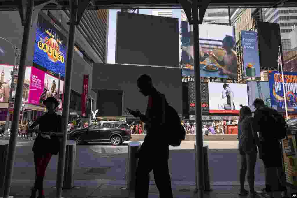 Peatones pasan frente a pantallas apagadas debido al apagón tecnológico global en Times Square, el viernes 19 de julio de 2024, en Nueva York.