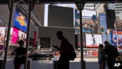 Seorang pejalan kaki melintasi layar gelap di Times Square akibat pemadaman teknologi global pada Jumat, 19 Juli 2024, di New York. (Foto AP/Yuki Iwamura)