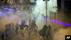 Protesters react from tear gas fired by riot policemen during the anti-extradition bill protest at Causeway Bay in Hong Kong, Aug. 4, 2019.