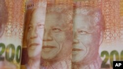 FILE: A portrait of the late Nelson Mandela is photographed on two hundred rand bills in Johannesburg. taken Thurs. Dec. 10, 2015. 
