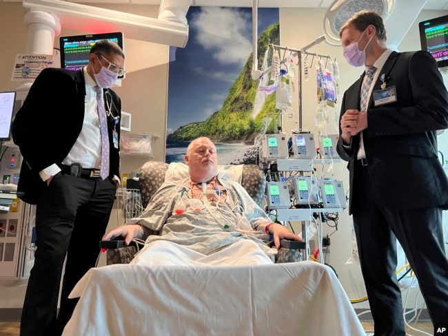 In this photo provided by the Mayo Clinic, Dr. Girish Mour, left, and Dr. David Lott, right, stand on either side of Marty Kedian one week after his transplant surgery in Phoenix, March 8, 2024. (Mayo Clinic via AP)