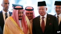 Raja Saudi Salman, kiri, berdiri di sebelah Perdana Menteri Malaysia Najib Razak setelah upacara penyambutan di Kuala Lumpur, Minggu, 26 Februari 2017.