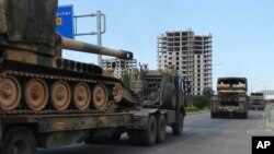 FILE - A convoy of Turkish military trucks carrying tanks destined for Syria, moves near the town of Kilis, Turkey, Sept. 14, 2018. 