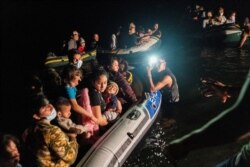 Asylum-seeking migrant families arrive at the U.S. side of the bank on inflatable rafts after crossing the Rio Grande into the U.S. from Mexico in Roma, Texas, Aug. 12, 2021.