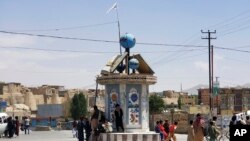 Bendera Taliban berkibar di sebuah alun-alun di kota Ghazni, Afghanistan, setelah pertempuran antara Taliban dan pasukan keamanan Afghanistan Kamis, 12 Agustus 2021. (AP Photo/Gulabuddin Amiri)