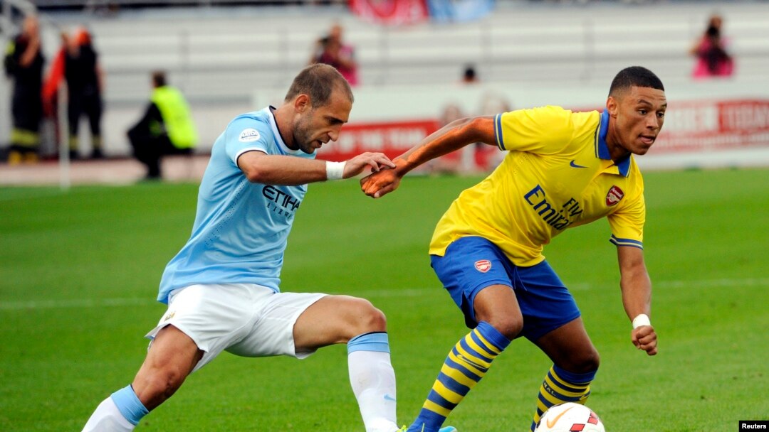 Pemain belakang Manchester City, Pablo Zabaleta (kiri) berusaha merebut bola dari pemain Arsenal Alex Oxlade-Chamberlain dalam pertandingan persahabatan Liga Premier Inggris di stadion Olimpiade Helsinki, Finlandia, 10 August 2013 (Foto: dok). Zabaleta telah menandatangani perpanjangan kontrak empat tahun dengan klub Manchester City.