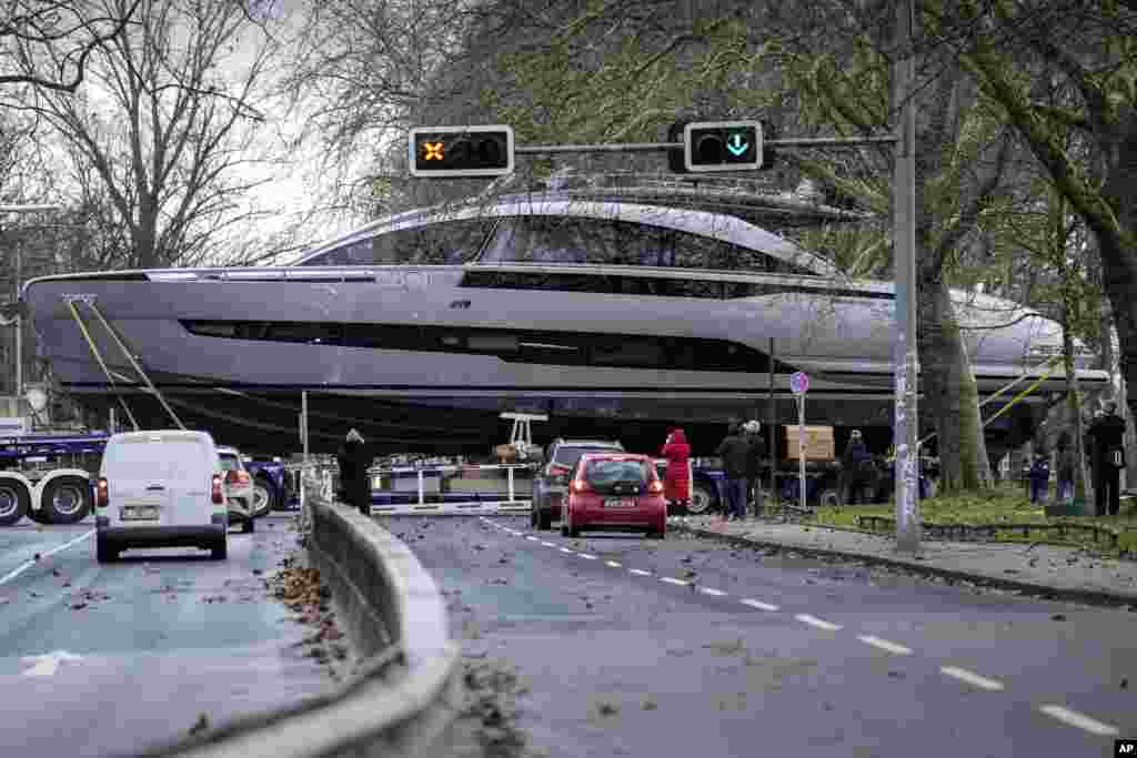 An Italian 50-ton luxury yacht Pershing GTX 80 crosses a street in front of waiting cars on its way to the upcoming boat fair in Duesseldorf, Germany.