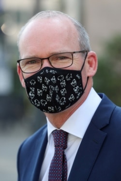 FILE - Irish Foreign Minister Simon Coveney, wearing a face mask, is seen after a European general affairs ministers council, in Brussels, Belgium, Sept. 22, 2020.