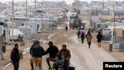 Syrian refugees travel on the main street of Al Zaatari refugee camp in the Jordanian city of Mafraq, near the border with Syria, Jan. 15, 2015.