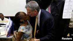 El candidato demócrata para la alcaldía de Nueva York, Bill De Blasio besa a su esposa Chirlane McCray después de emitir su voto en Brooklyn.