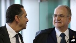 Supreme Court Judge Edson Fachin, right, talks with fellow Judge Luis Roberto Barroso as they arrive for the second day of debate on the impeachment proceedings opened against Brazil’s President Dilma Rousseff, in Brasilia, Dec. 17, 2015.